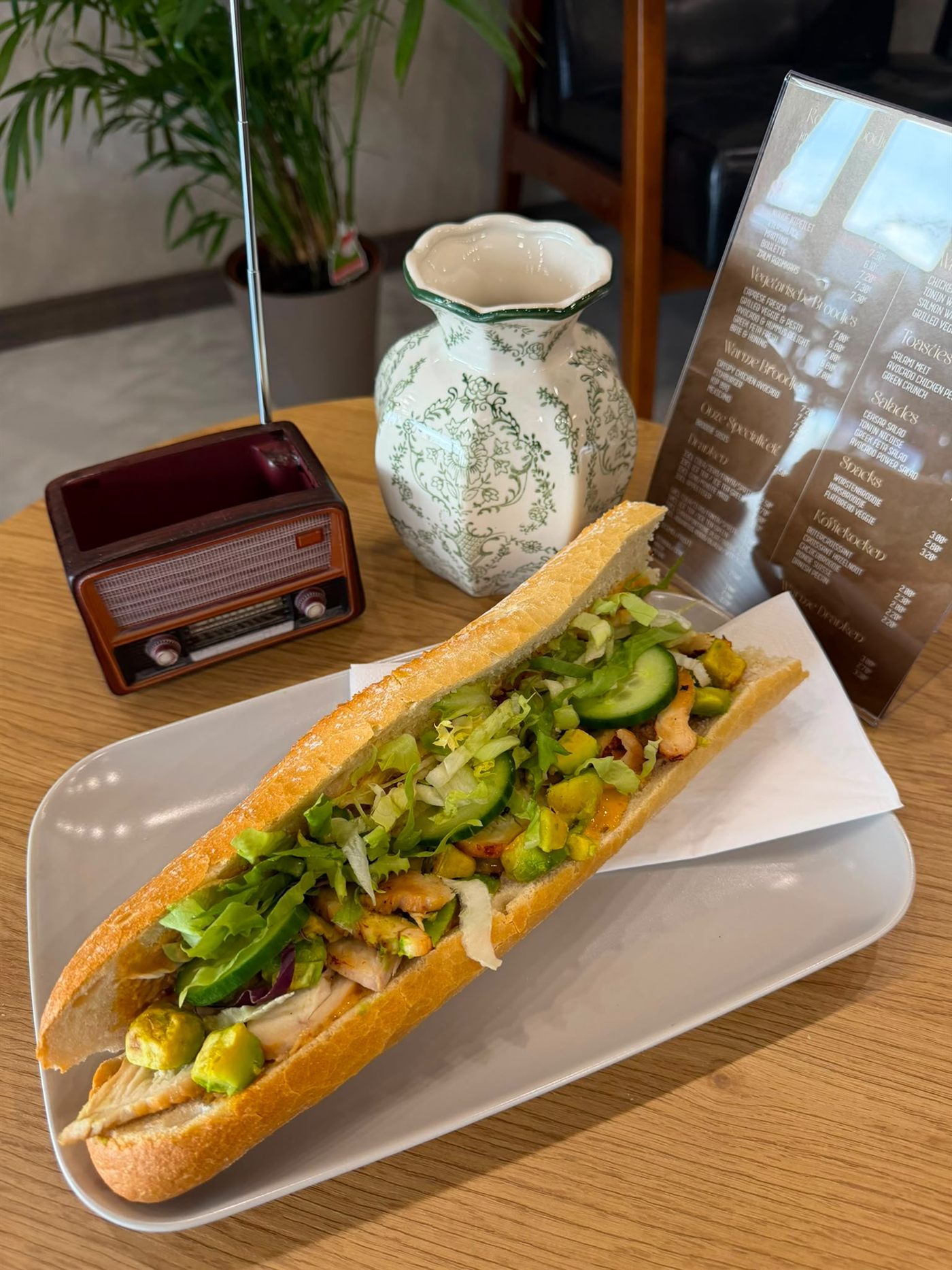 Baguette met kip en avocado op een houten tafeltje in de zaak